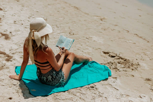 istock Woman Relaxing at Beach on Chair with Electronic Book Reader 1494768223