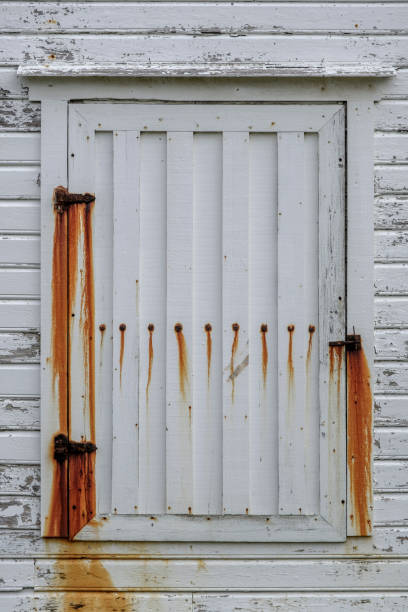 old white painted wooden door or shutter showing heavy rust staining from hinges - wood shutter rusty rust imagens e fotografias de stock