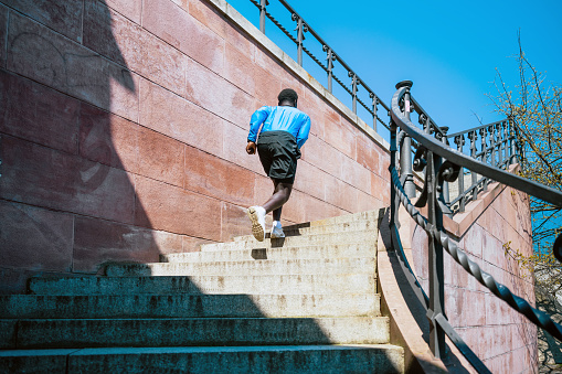young sportsman running up steps outdoors in berlin at sunny day