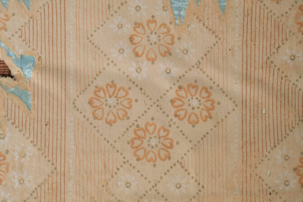 Old wallpaper on the wall. Old torn wallpaper for texture or background.
