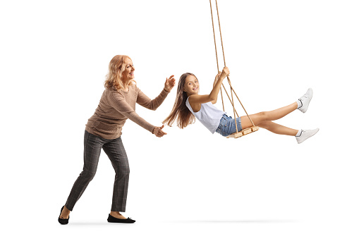 Mother pushing a girl on a swing isolated on white background