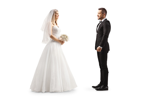 Full length profile shot of a bride looking at a groom isolated on white background