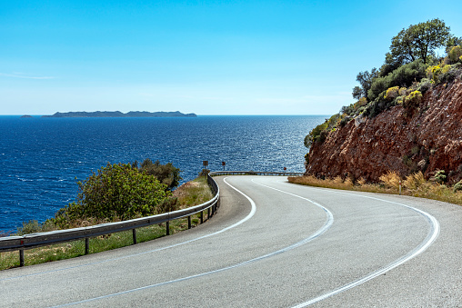 Close-up, winding road by mountain with sea and sky view. The road between Kaş (Kas) and Kalkan town in Turkey. Detail of the road.