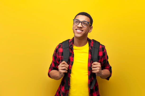 istock young guy african american student in glasses with backpack looks at copy space on yellow isolated background 1494781522