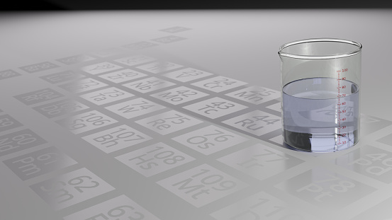 Clear blue liquid in a beaker sitting on a counter etched with the periodic table.