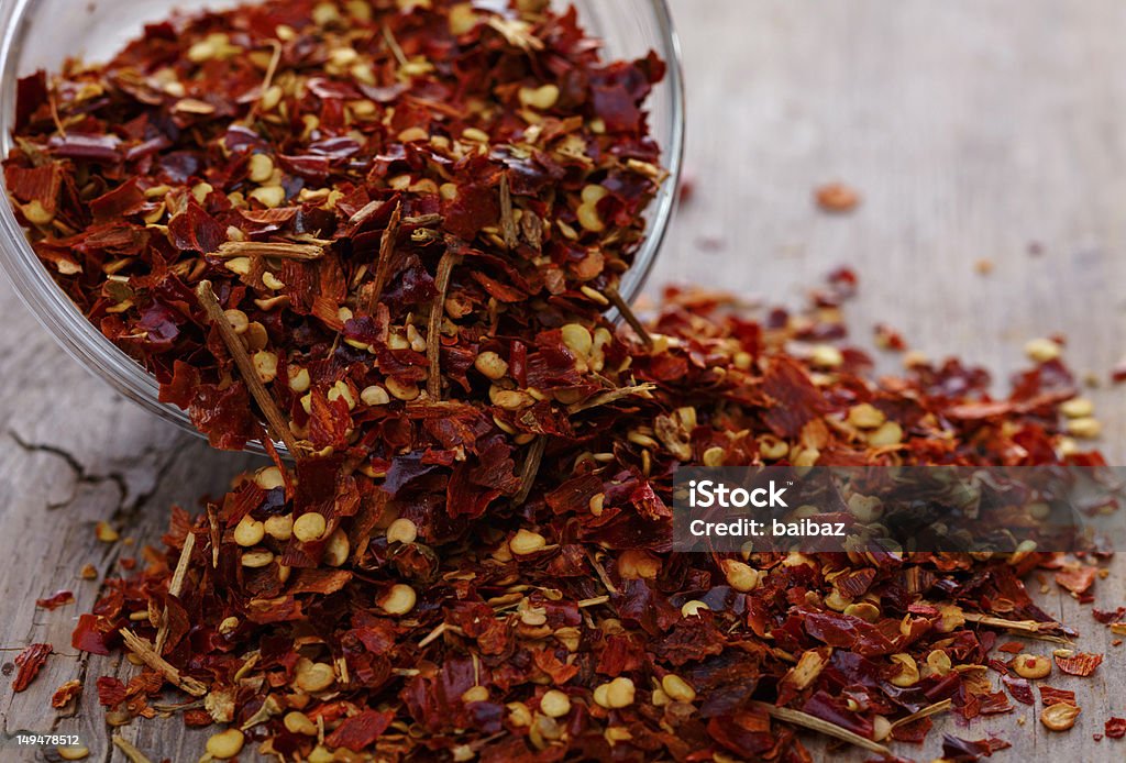 Crushed red peppers Bowl of crushed red peppers on wooden background Bowl Stock Photo