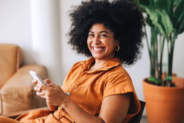 istock Businesswoman smiling cheerfully while holding a smartphone 1494790878