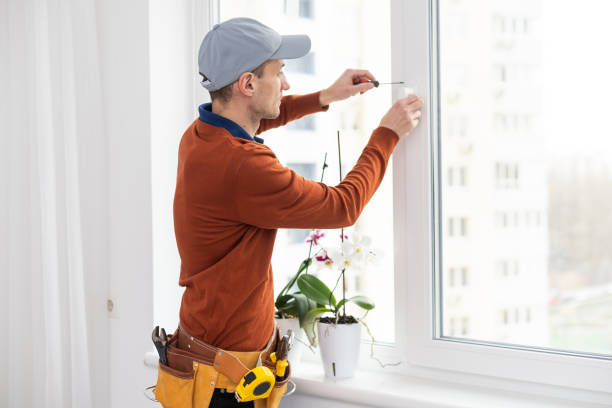 istock Workman in overalls installing or adjusting plastic windows in the living room at home 1494791692
