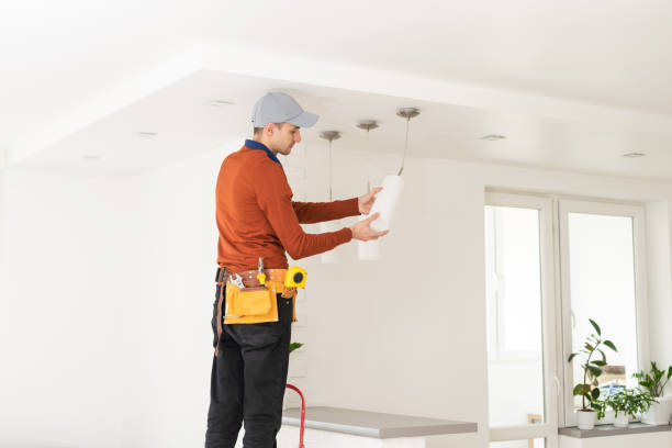 istock Electrician in uniform repairing ceiling lamp indoors 1494791893