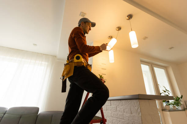 Electrician man working on exterior light, install LED replacement lamp at home. Maintenance concept.