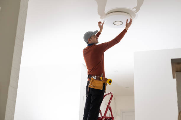 istock Electrician man working on exterior light, install LED replacement lamp at home. Maintenance concept. 1494792556