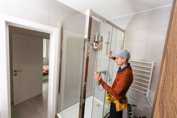 istock young foreman measuring shower cabin in modern bathroom. 1494792599