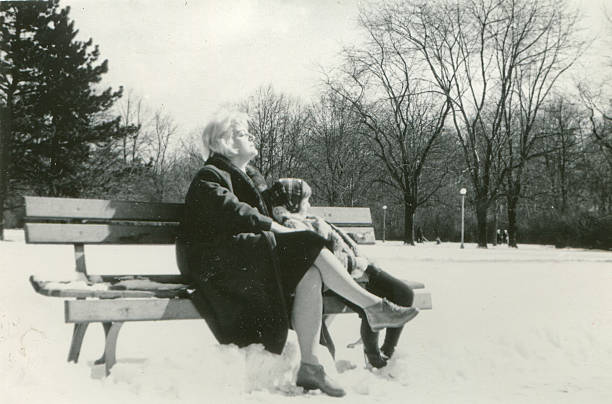 Vintage photo of mother and daughter sunbathing on bench stock photo