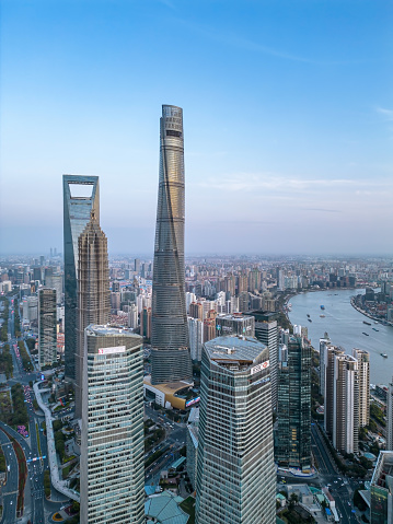 Shanghai, China- April 10,2023: The drone aerial view of three tallest buildings in Lujiazui financial and trade zone at dusk, Pudong, Shanghai, China.
