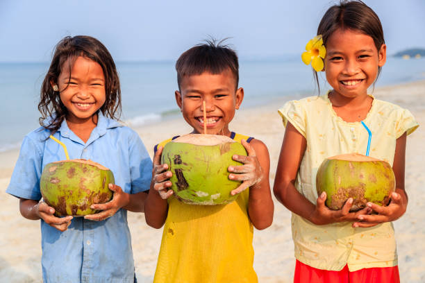 istock Cambodian children holding coconuts on the beach, Cambodia 1494797073