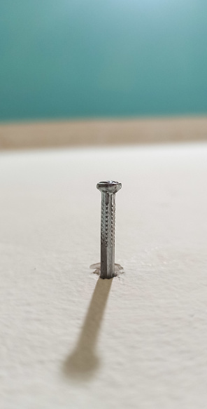 A nail stuck in the wall of a house in a close-up photo