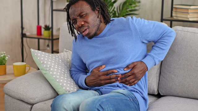 Young Man Having Stomach Pain At Home