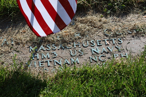 Vietnam war navy veteran cemetery tomb and Us flag.