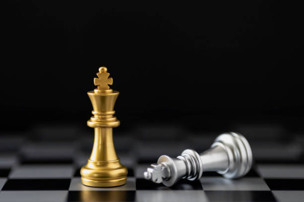 istock Golden king chess standing and silver king chess falling on chess board. 1494810582