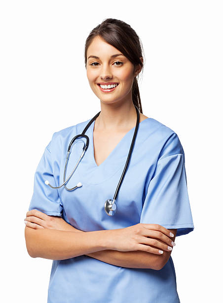 Female Surgeon Standing Arms Crossed - Isolated Portrait of an attractive young female surgeon in scrubs with stethoscope around neck standing arms crossed. Vertical shot. Isolated on white. female nurse stock pictures, royalty-free photos & images