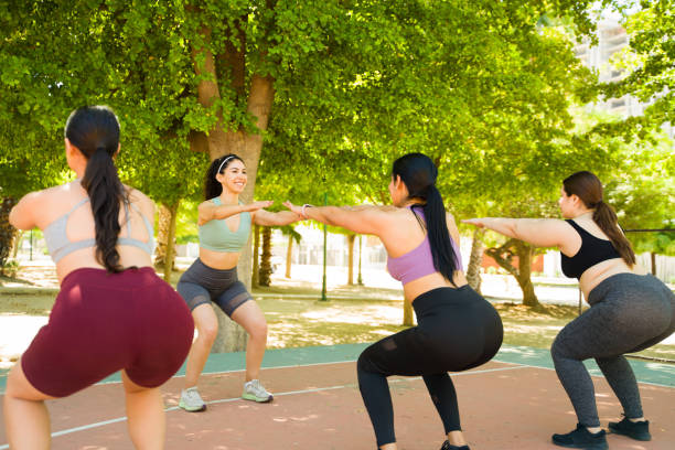 istock Attractive diverse women doing squat exercises outdoors 1494811577