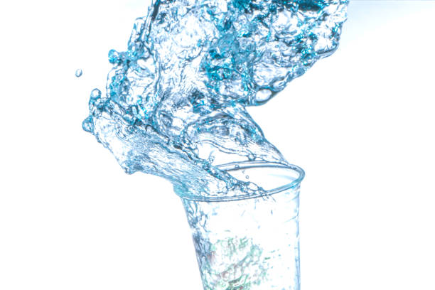 istock Drinking water splashing from the glass on white background 1494811857