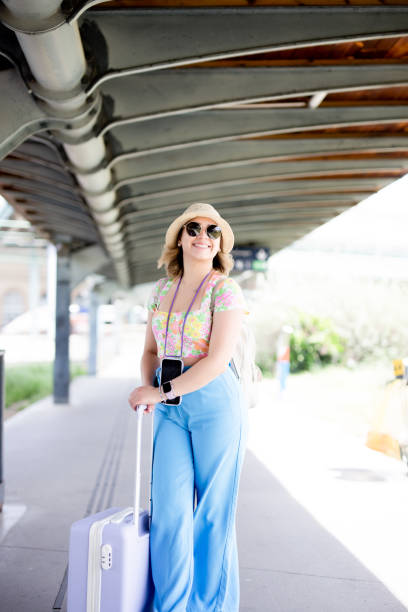istock Happy tourist at the train station with a suitcase 1494812023