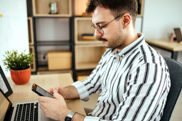 istock Portrait of man using smartphone in home office. 1494815019