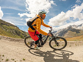 Female mountain biker on dirt trail, Switzerland