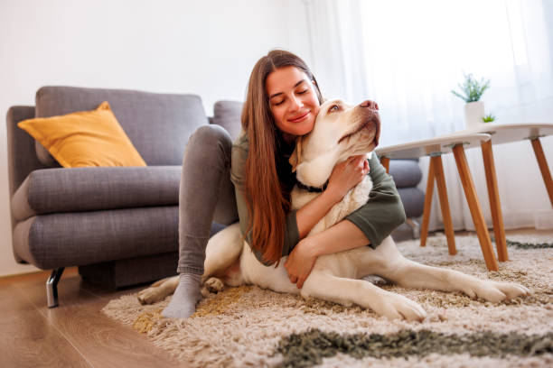 istock Woman relaxing at home hugging and cuddling her dog 1494817835