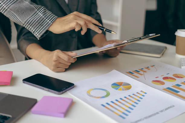 istock Asian businesswoman analyzes reports pointing to graphs, holding pens using laptops, business contacts, consulting to plan, financial statements, remote pictures. 1494825754