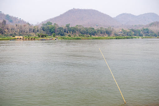 Mekong River, Luang Prabang, Laos - March 18th 2023: View cross the river to fancy hotels and tour boats from the the former capital of Laos