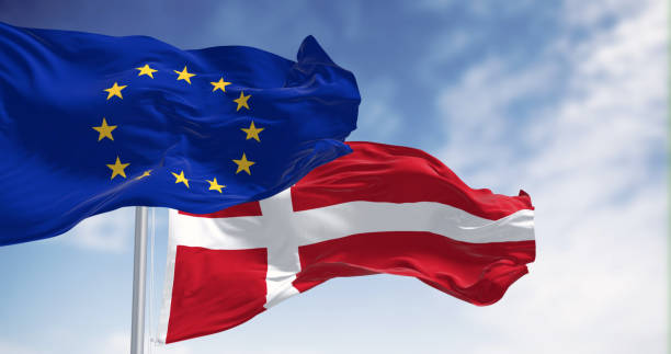 istock Flags of Denmark and EU flutter in wind against serene sky backdrop 1494828585