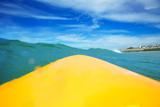 海の波の中でサーファーの視点から見たサーフィンボード