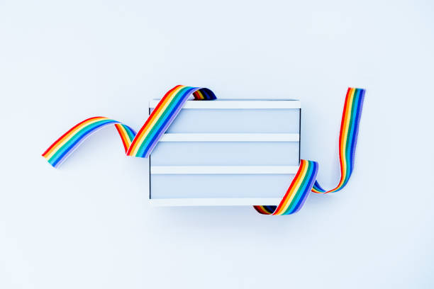istock Top view White light box mockup with rainbow LGBT ribbon on a light background isolated. Copy space for text or design. Pride month tape symbol. Gender equality, lgbtq concept. Selective focus. 1494832079