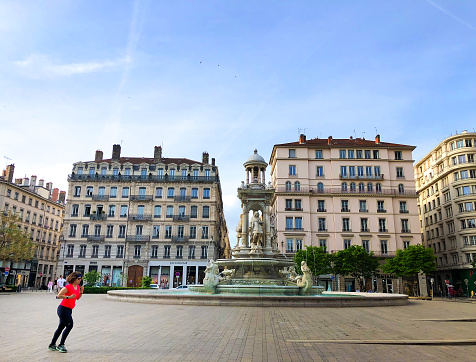Lyon, France: A woman jogs in the morning on Place des Jacobins, a 16th century square in the Presqu’ile district within the UNESCO World Heritage zone.