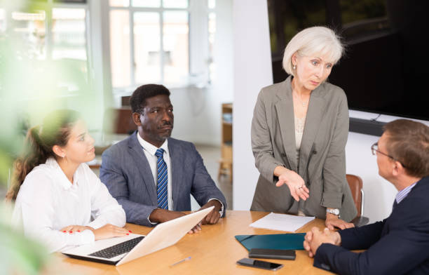 istock Group of different people arguing at table in office 1494834112