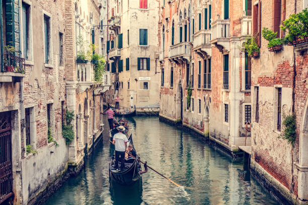istock Gondolier rowing gondola on canal in Venice, Italy. 1494835931