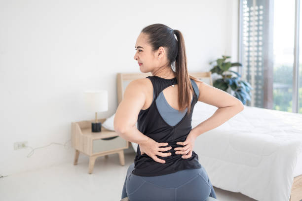 sports woman having back pain stock photo