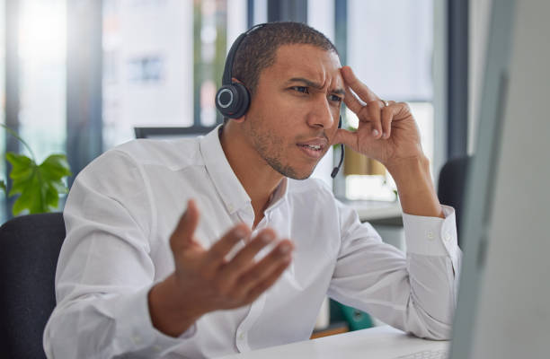 istock Confused, stress or frustrated black man in call center angry with 404 error at customer services help desk. Doubt, faq or mad sales consultant with mistakes or problems in a telemarketing company 1494836163