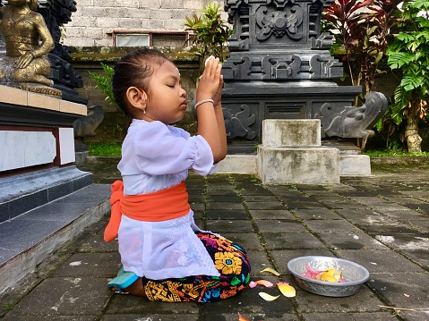 Balinese little girl are doing worship on the big day of Hindus, namely Galungan