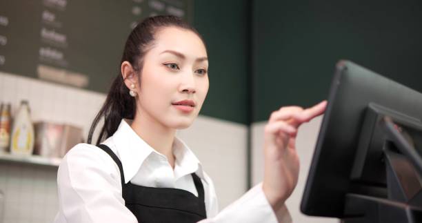 istock Close up woman barista or owner in apron using computer take order from customer in coffee shop. Coffee business concept 1494838884