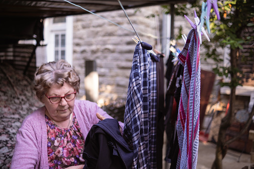 In summer, grandmother likes to take her clothes out to dry in the garden