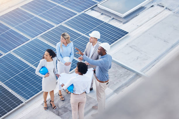 istock Solar energy, teamwork or engineering team on roof by future electricity technology innovation together. Collaboration, top or black man talking or planning a grid sustainability project with people 1494842981