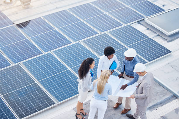 istock Solar energy, design or engineering team on roof building sustainable future electricity technology innovation. Collaboration, top or black man talking or planning a construction project with people 1494844003