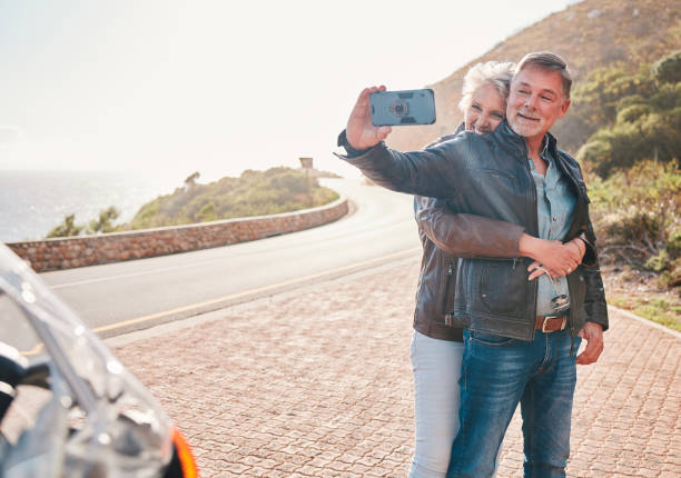 mountain, bikers and couple taking a selfie together while on an adventure, vacation or weekend trip. freedom, nature and senior man and woman in retirement taking a picture while on a motorbike ride - action mature adult bicycle senior couple imagens e fotografias de stock