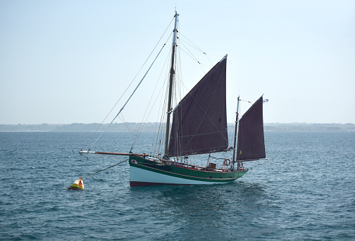 Sailing crew yachting on sailboat on summer day.