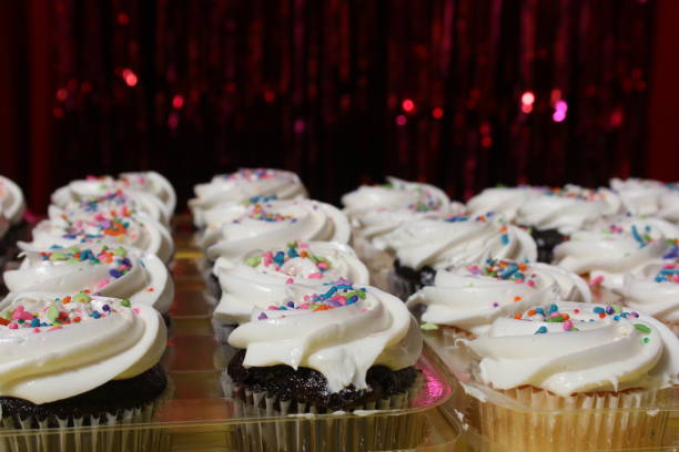 Sweet cupcake with birthday decoration on pink background
