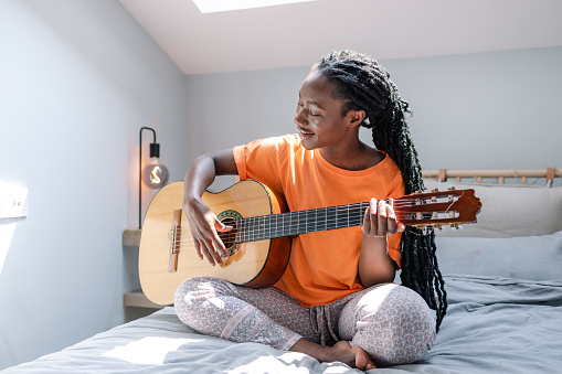 Young woman playing a guitar in the morning