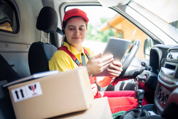 istock Female delivery worker in the delivery truck using digital tablet. 1494857608